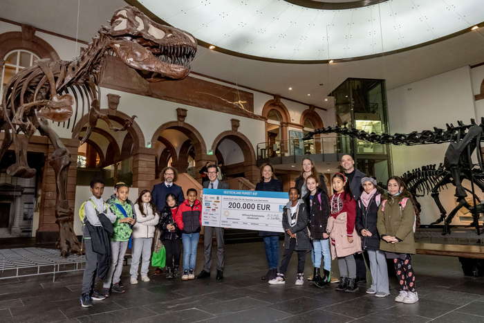 Spendenübergabe im Senckenberg Naturmuseum Frankfurt vor den Skeletten der Dinosaurier. Foto: Philip Eichler